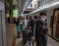 Decenas de pasajeros llegados de Wuhan en una estación de Pekín. / EFE