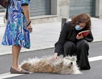 La presidenta de la Comunidad de Madrid, Isabel Diaz Ayuso, este sábado acaricia un perro en la calle Mayor de Madrid. /EFE/J.J. Guillen